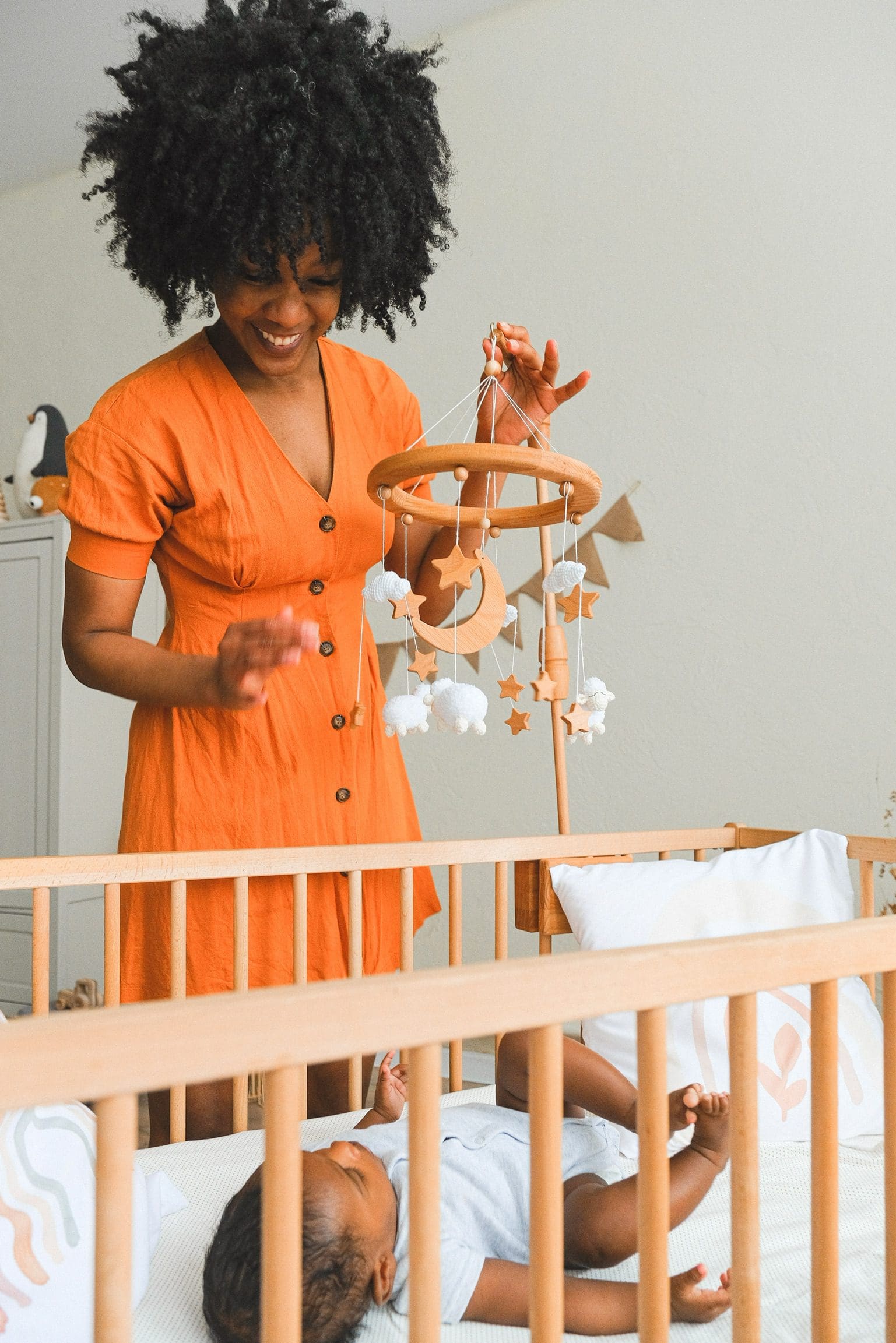 A woman is playing with a baby in a crib at the Safi Marketplace.