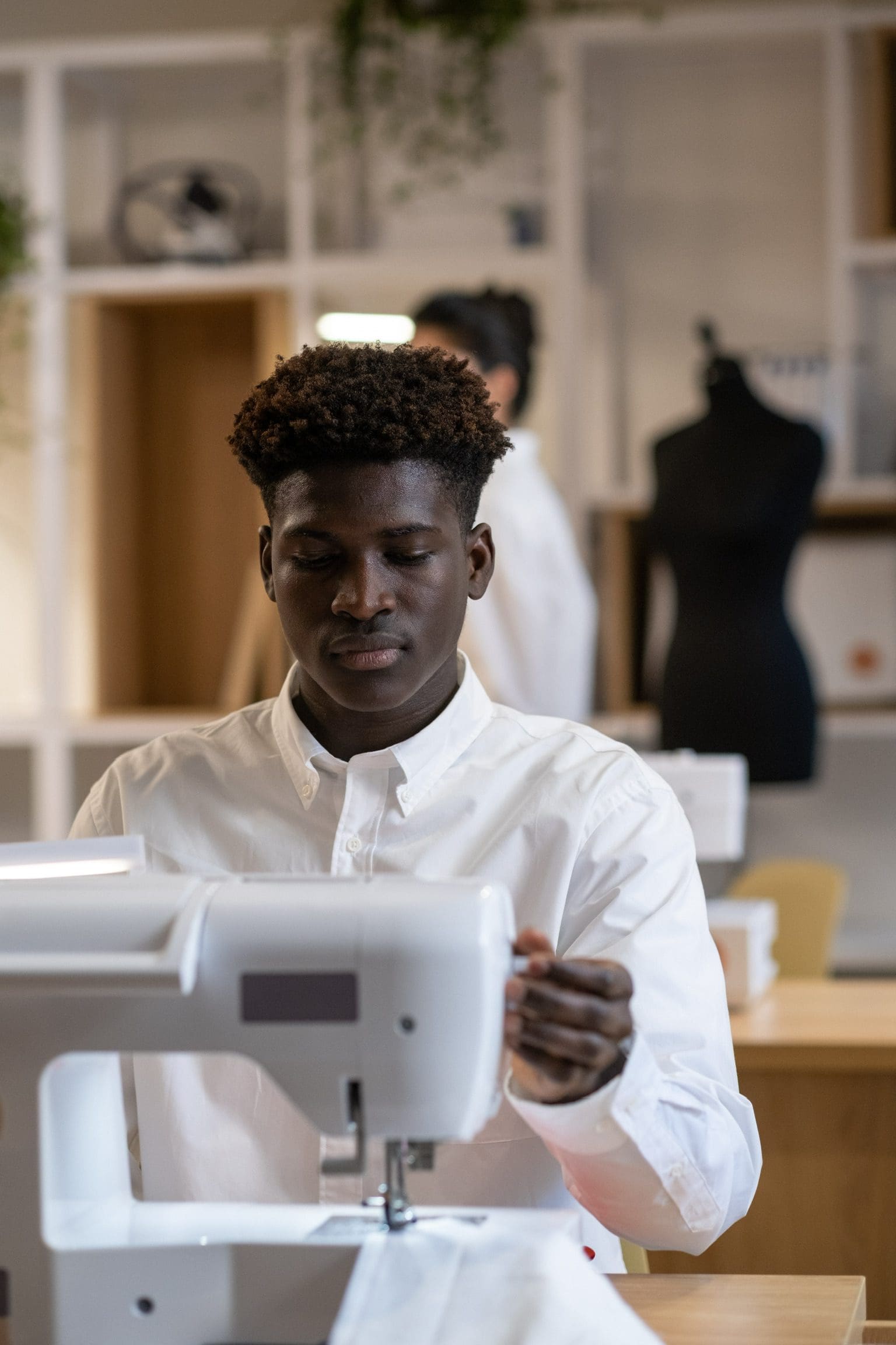 A young man working on a sewing machine at Safi Marketplace.