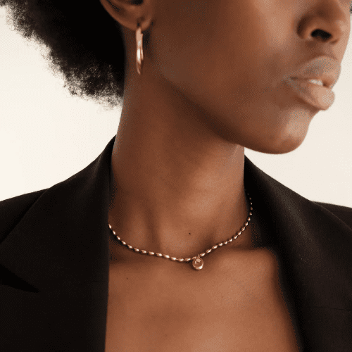 A black woman wearing a choker and a black jacket shops at Safi Marketplace.