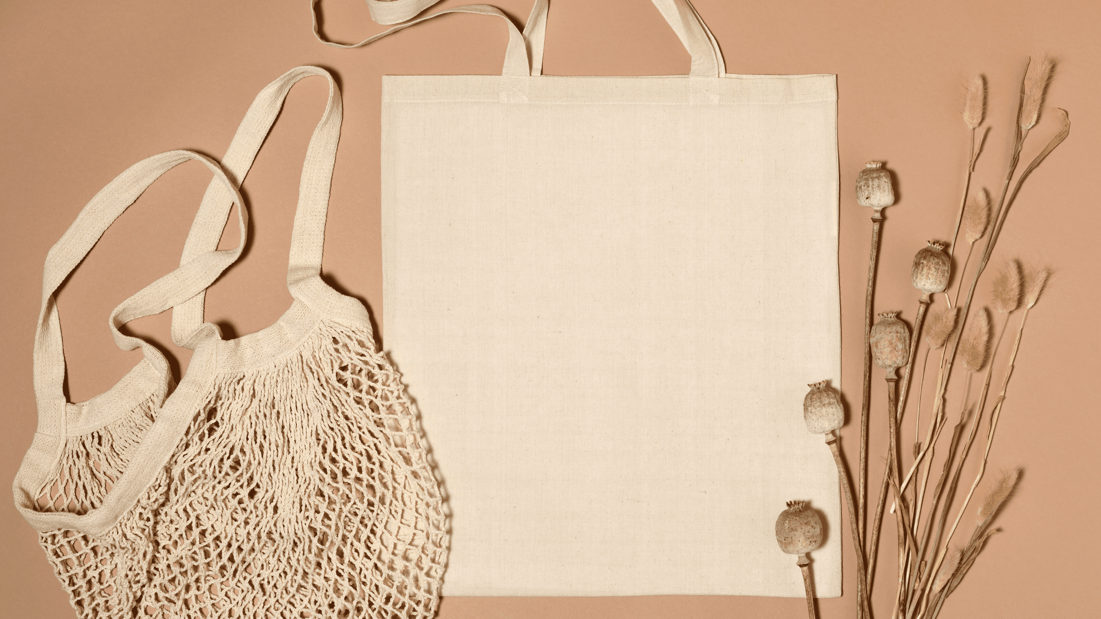 A shopping bag and dried flowers on a beige background.