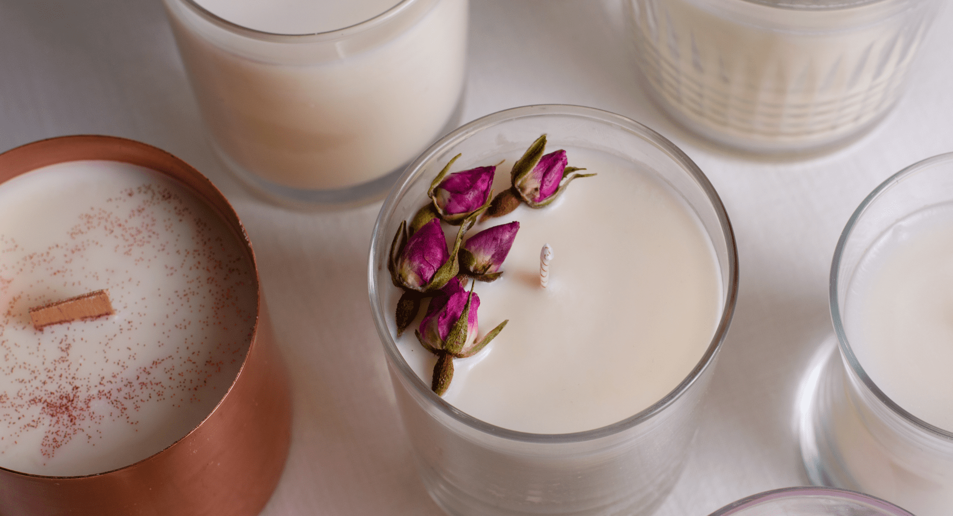 A group of candles with flowers in them.