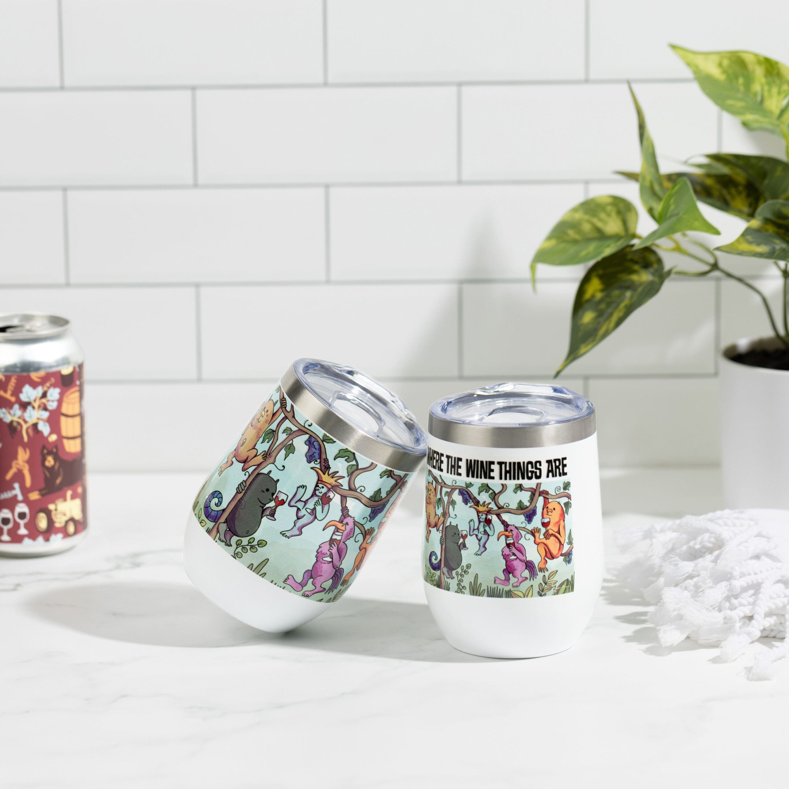 Two wine tumblers on kitchen counter with a wine can to the left and potted plant to the right