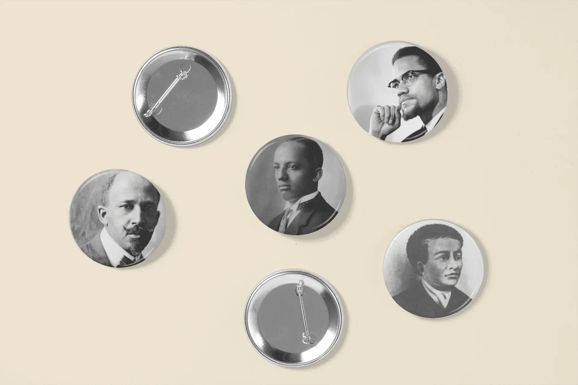 Five pin buttons featuring black and white portraits of notable historical figures.