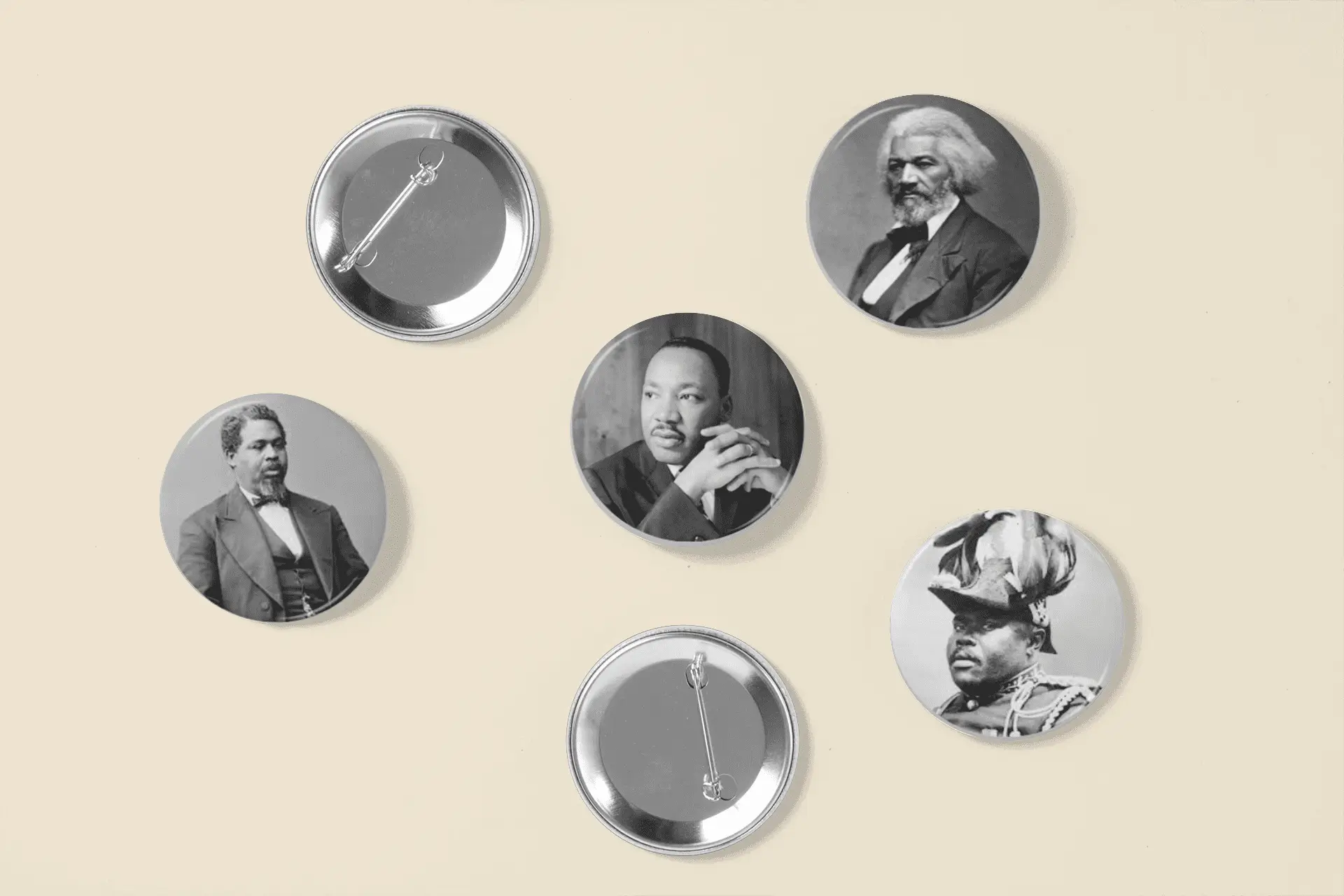 Five pin buttons featuring images of historical figures including Martin Luther King Jr. and Frederick Douglass.